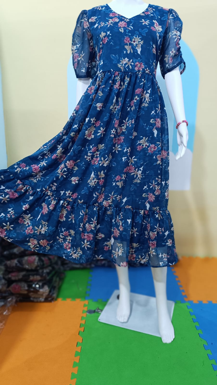 Blue floral dress on a mannequin against a plain background