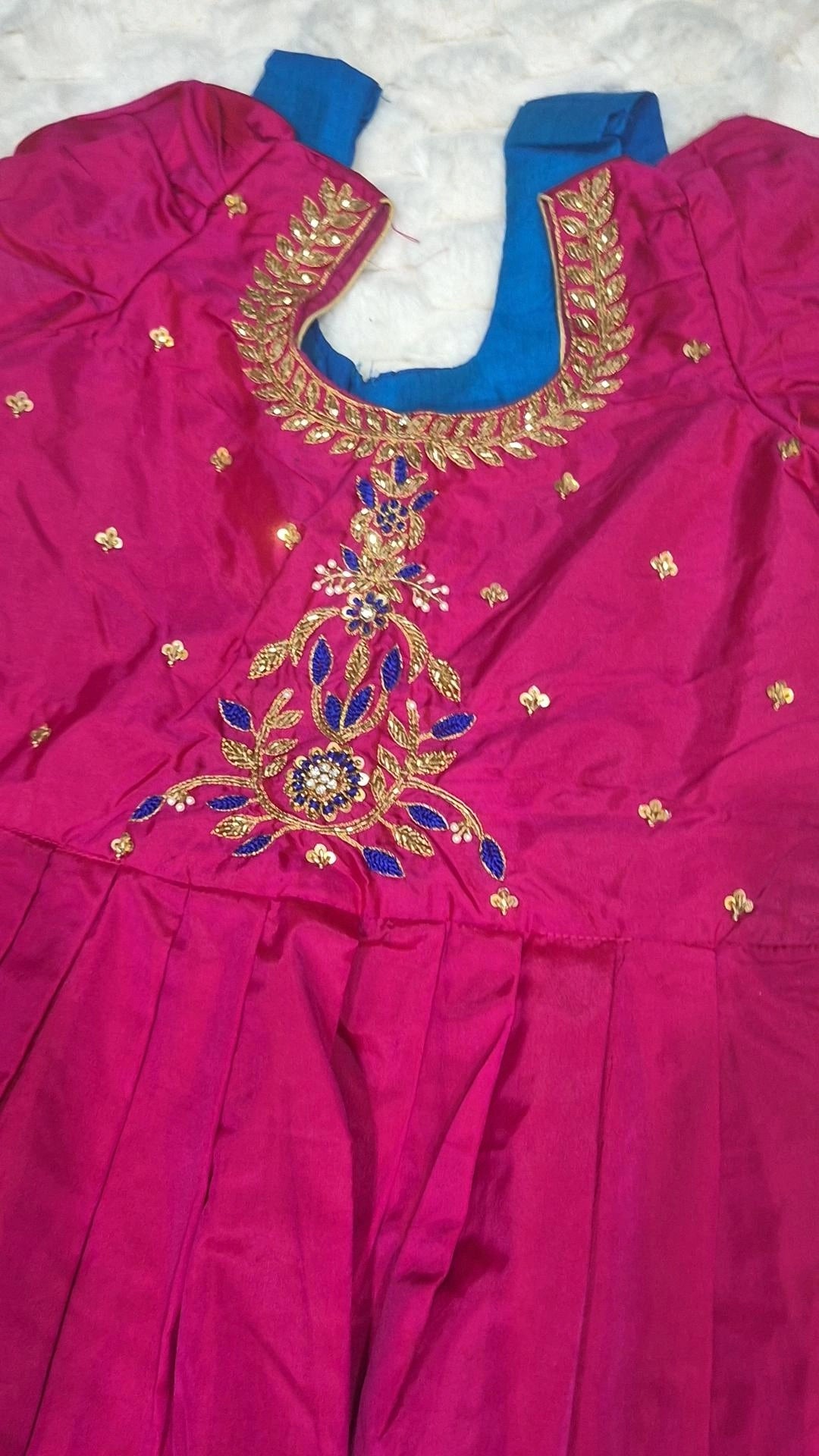 Magenta embroidered blouse with gold and blue floral vine motif close-up