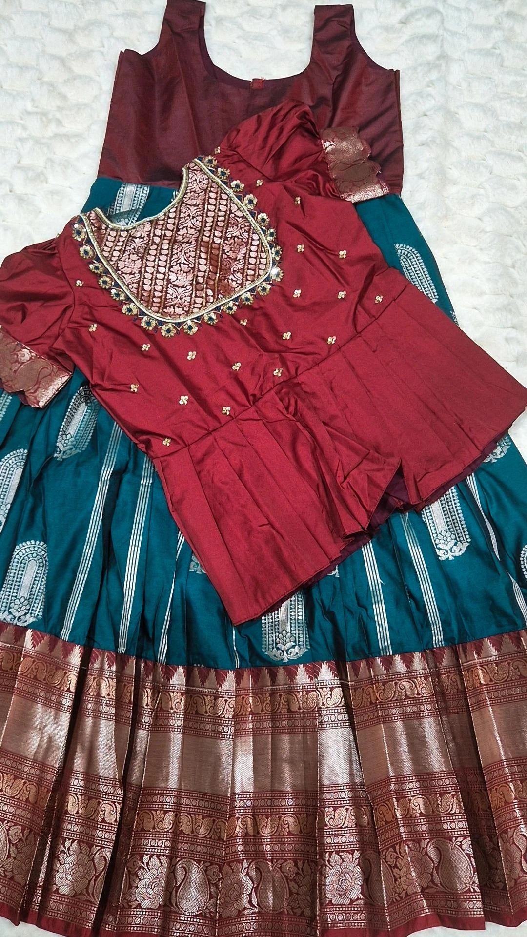 Maroon embroidered blouse with teal pattu pavada skirt