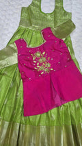 Hot pink embroidered blouse with gold floral bouquet motif and parrot green pattu pavada skirt
