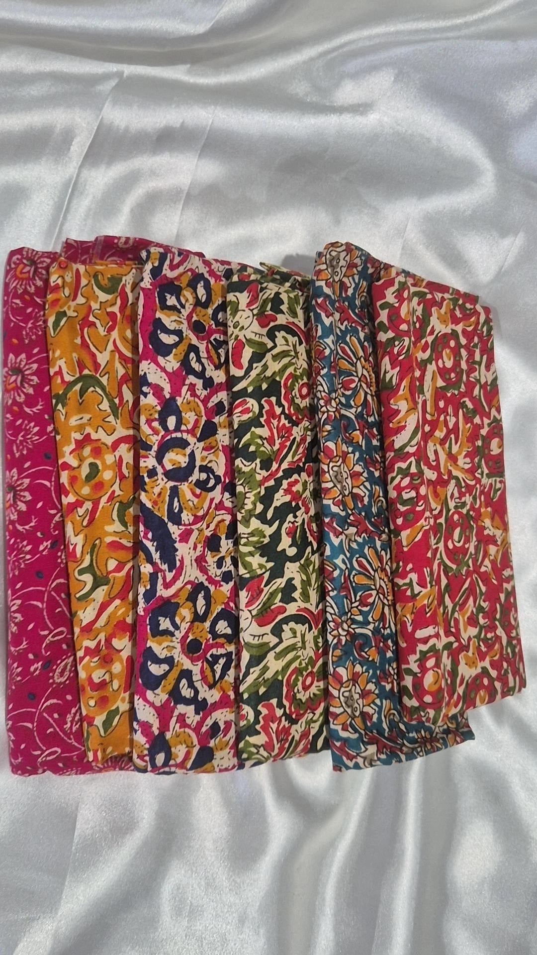 Six Indian block print blouse pieces fanned out showing warm floral tones