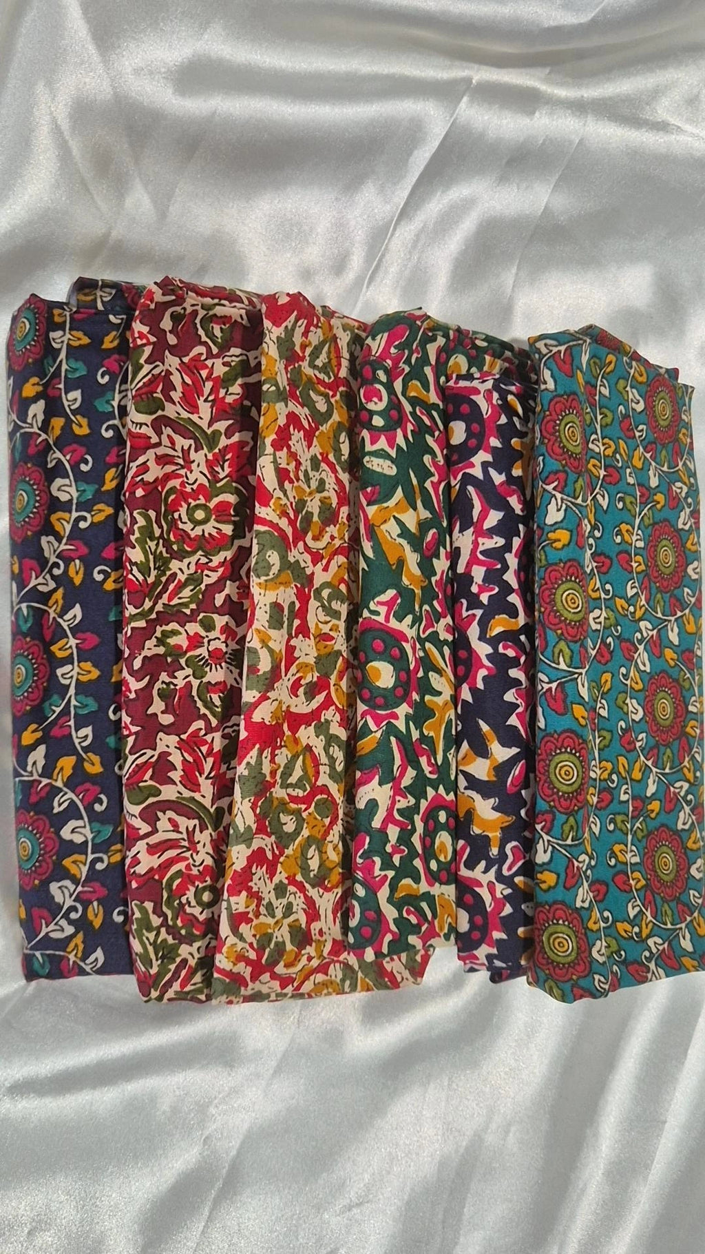 Six Indian block print blouse pieces fanned out showing cooler tones with teal mandala