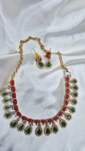 Gold-tone kundan necklace and earring set with coral beads and emerald teardrop stones