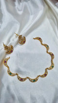 Gold-tone crescent necklace and matching stud earrings with white, ruby, and emerald stones