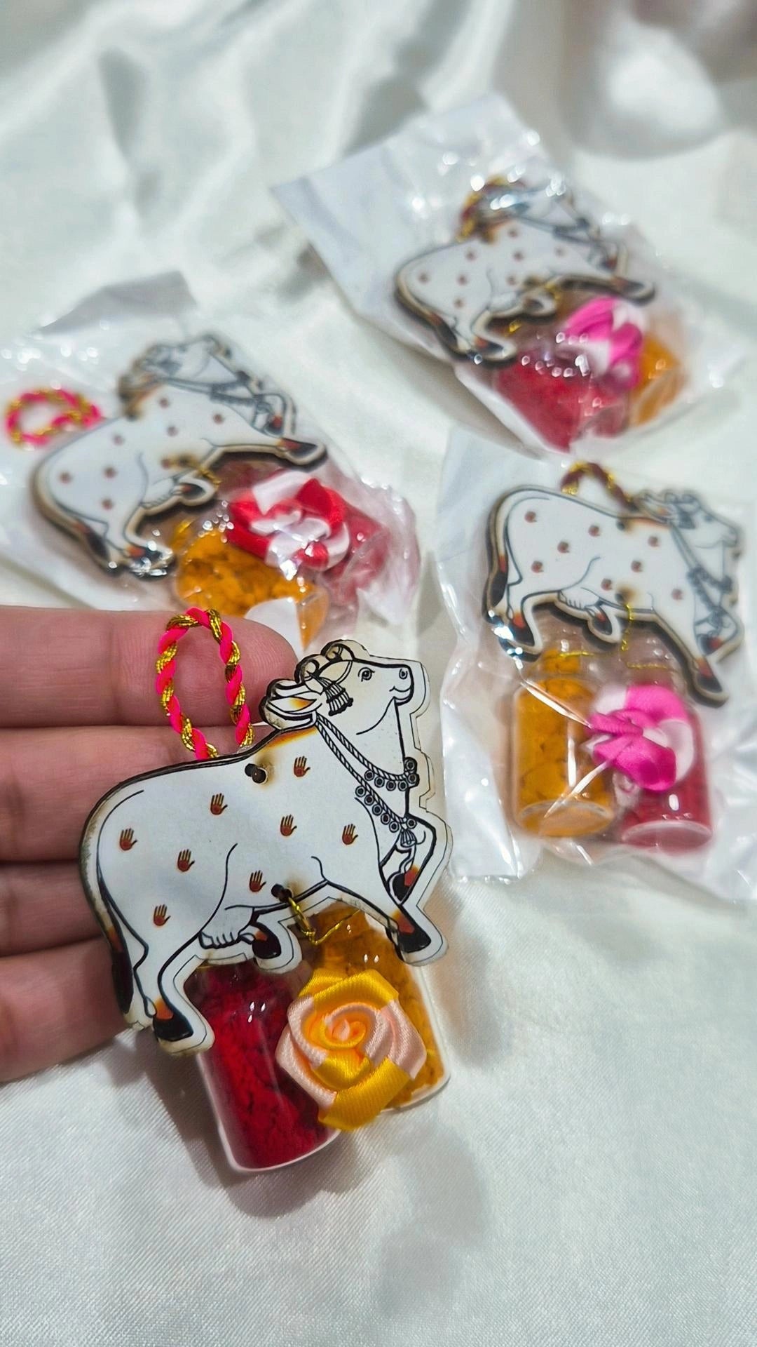 Kamdhenu cow haldi kumkum favors packaged on white fabric