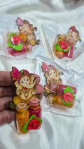 Ganesha haldi kumkum favors packaged on white fabric