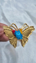 Golden metal butterfly favor with bright ribbon and haldi kumkum details
