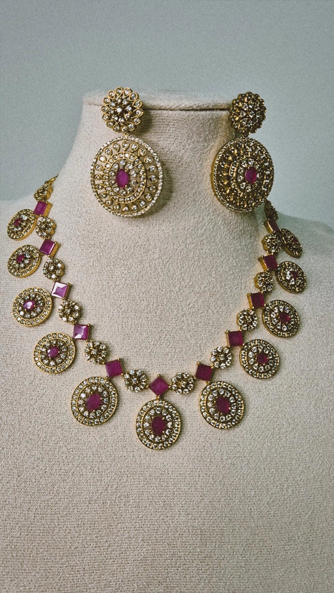 Victorian ruby Bottu Mala necklace with antique gold CZ medallions and ruby square links displayed on jewellery bust with earrings