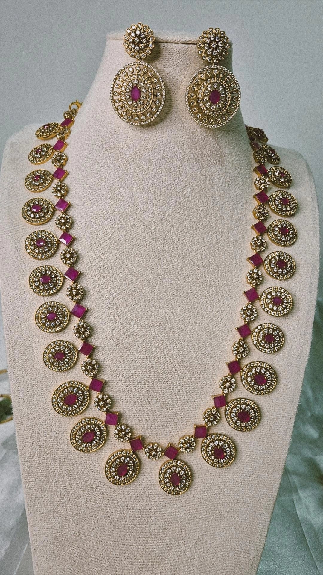Victorian ruby long Bottu Mala necklace set with CZ pavé oval medallions and matching drop earrings on jewellery bust