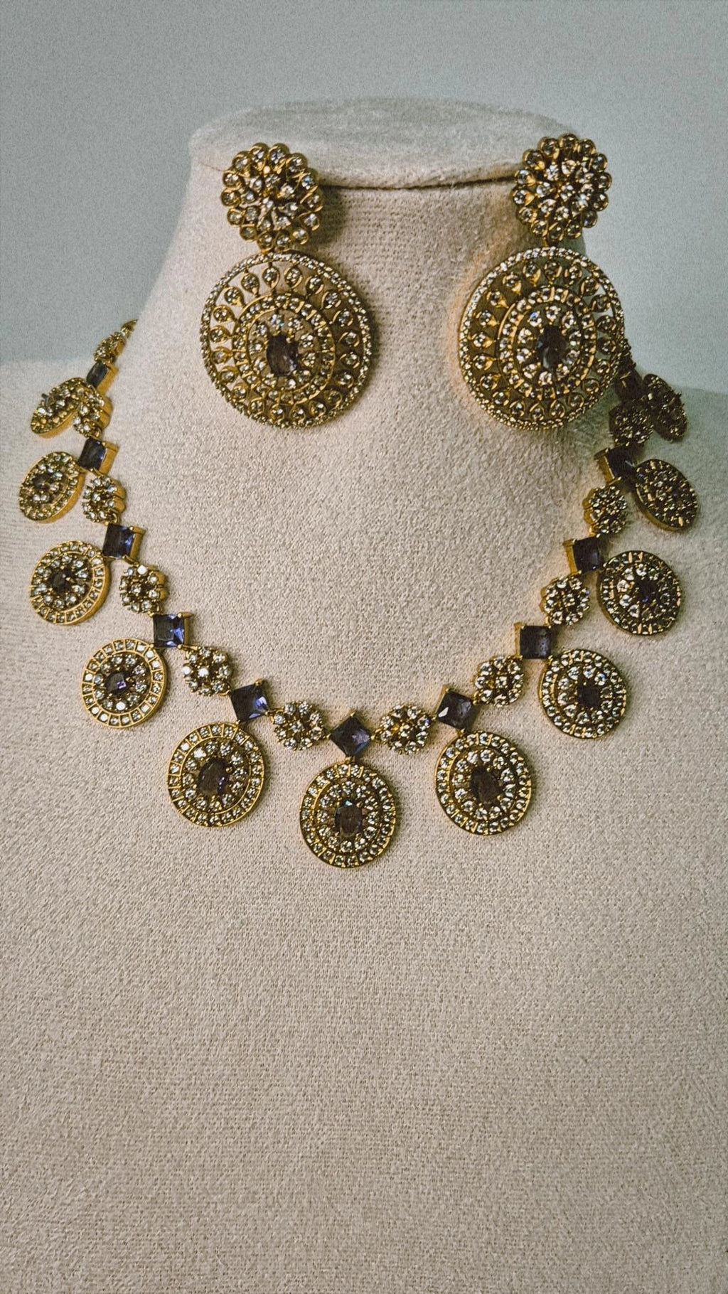 Victorian gold CZ Bottu Mala necklace set with sapphire blue links and matching circular drop earrings on jewellery bust