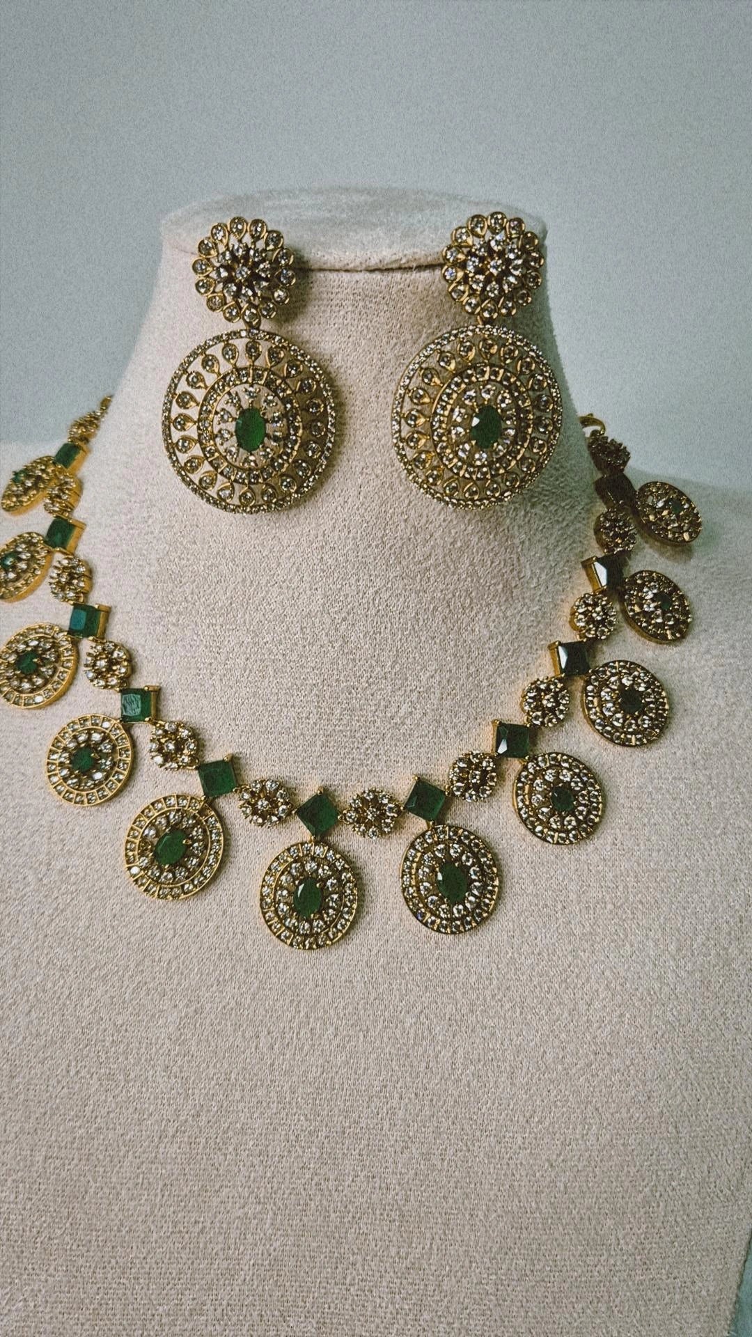 Victorian gold CZ emerald Bottu Mala necklace set with emerald green links and matching circular drop earrings on jewellery bust