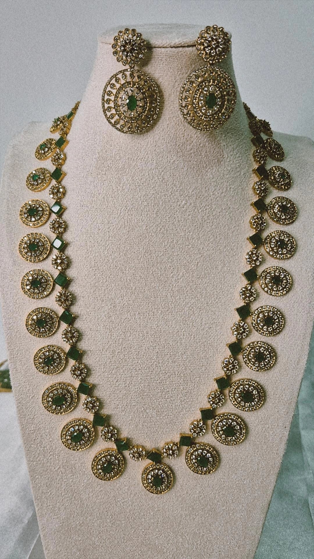 Victorian antique gold CZ long Bottu Mala necklace with emerald oval stones and square links displayed on jewellery bust with earrings