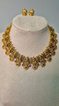 Lakshmi temple antique gold choker necklace with ruby and emerald stone accents and matching Lakshmi stud earrings on jewellery bust