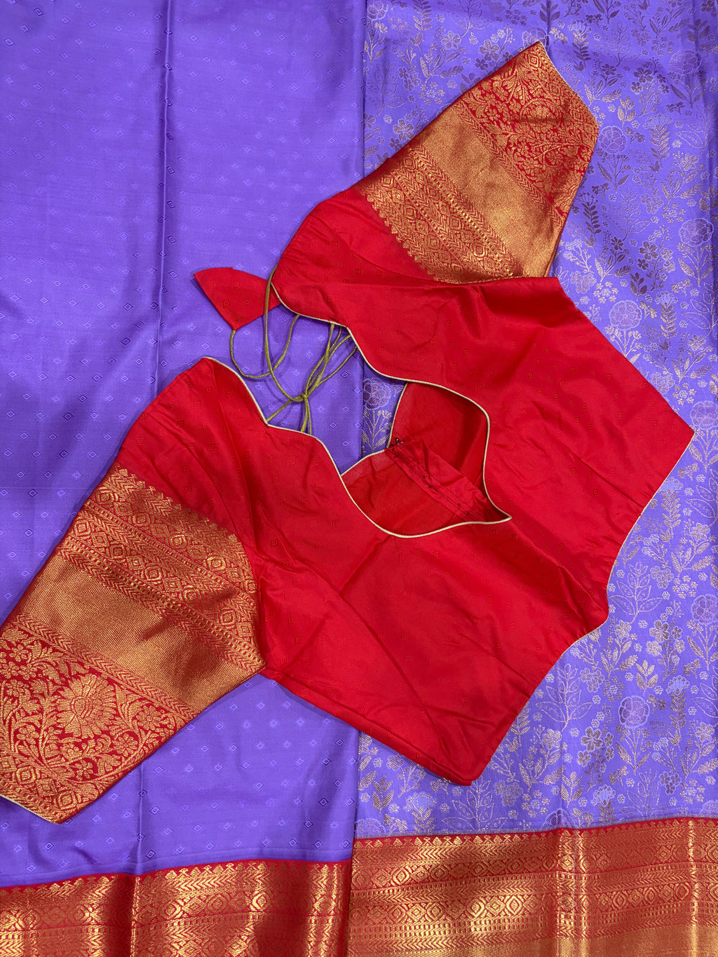 Purple Kanjivaram saree folded showing red gold zari border and pallu