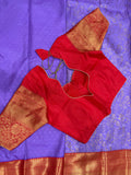 Purple Kanjivaram saree folded showing red gold zari border and pallu