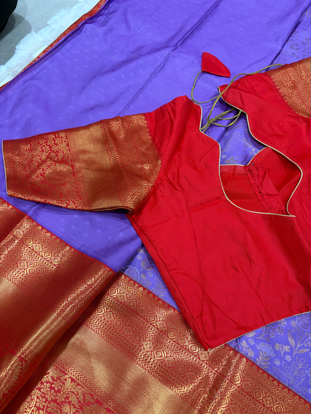 Close up of red Kanjivaram pallu with gold zari weave and purple saree body