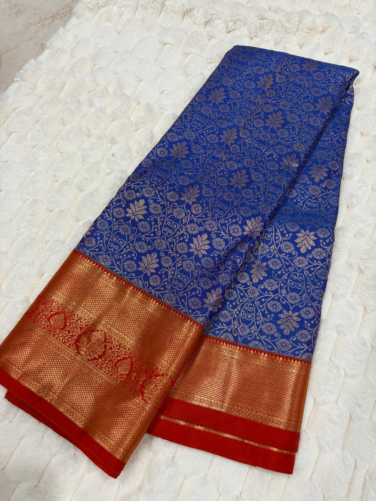 Royal blue Kanjivaram silk saree folded showing all-over silver zari jaal and red gold border