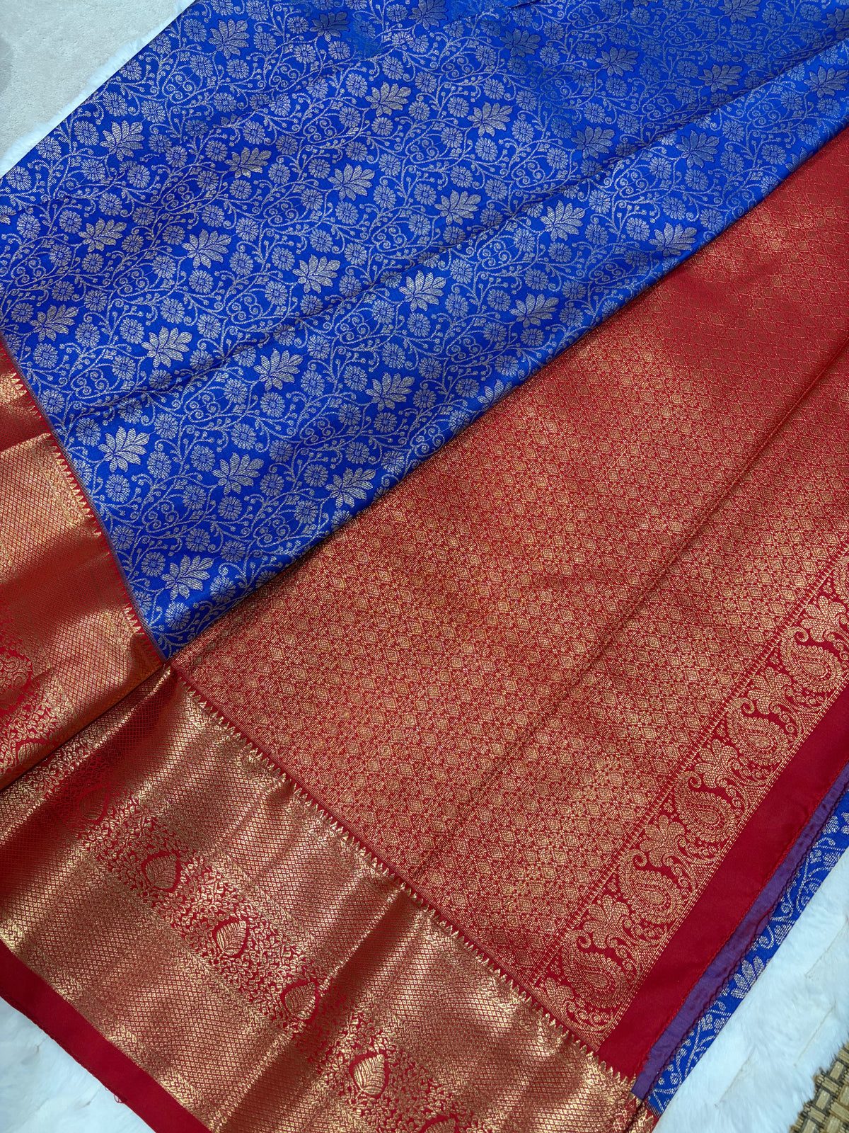 Red stitched blouse with sweetheart back neckline, gold piping and dori ties on blue saree