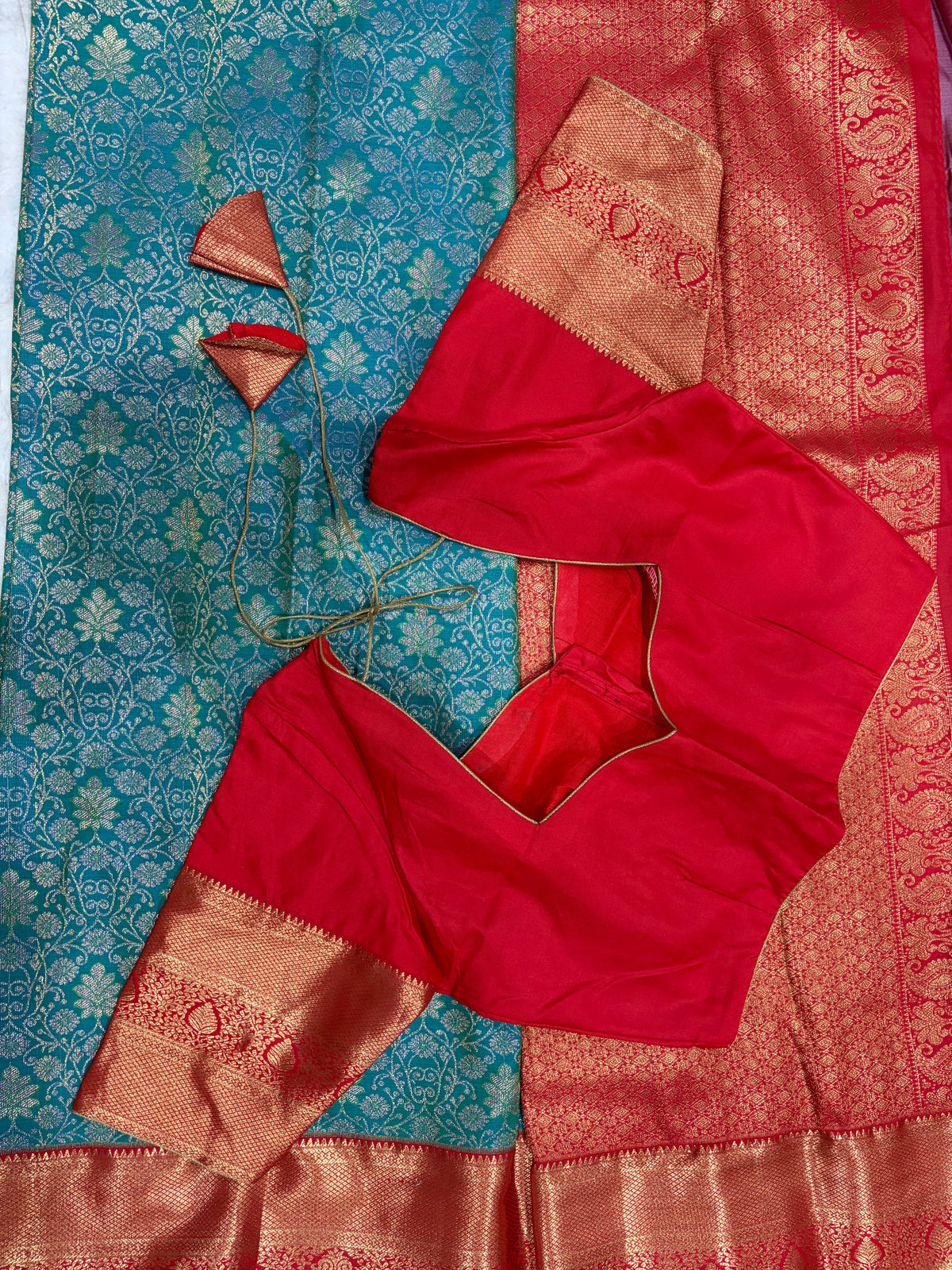 Red boutique stitched blouse with Kanjivaram zari sleeves laid on teal saree with dori ties - back view