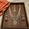 Silver emerald bridal necklace set on wooden tray