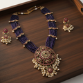 Purple kundan necklace set on wooden tray