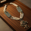 White pearl teal necklace on wooden tray