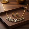 Gold kundan necklace set on wooden tray