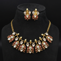 Gold kundan ruby red leaf necklace set on wooden tray