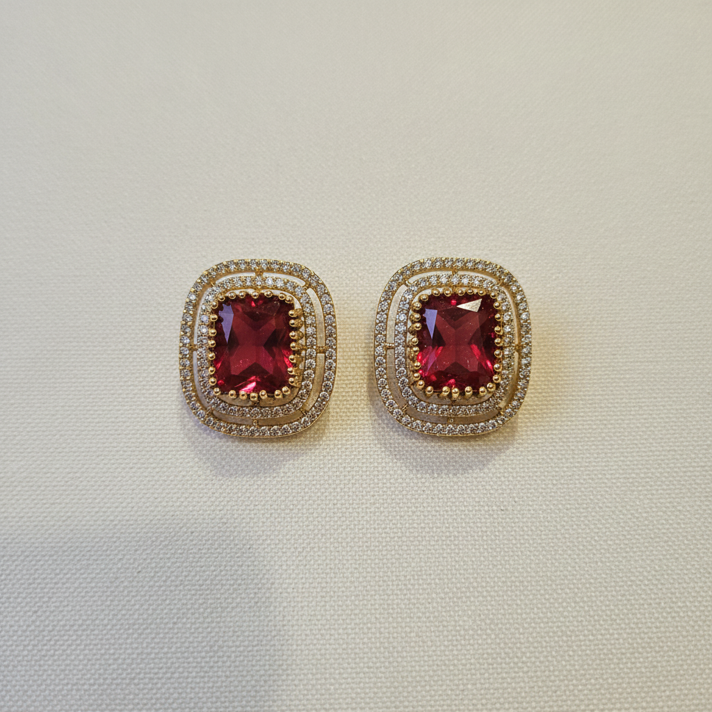 Gold Red Ruby CZ Cushion Studs - cream flat lay
