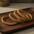 Antique gold filigree bangles on wooden tray