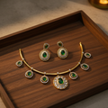 Gold emerald hasli choker on wooden tray